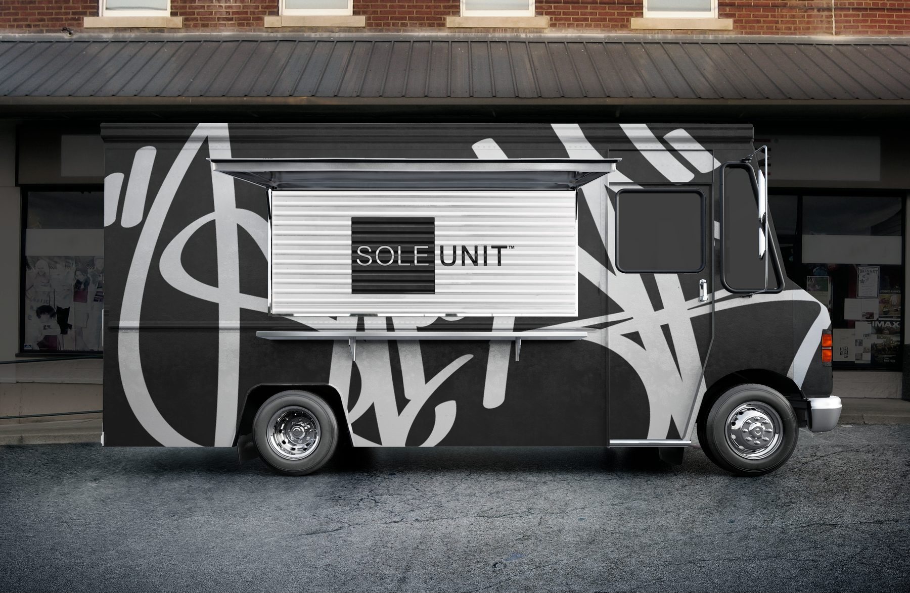 The Sole Unit truck outside a storefront, wrapped in black and white calligraphy